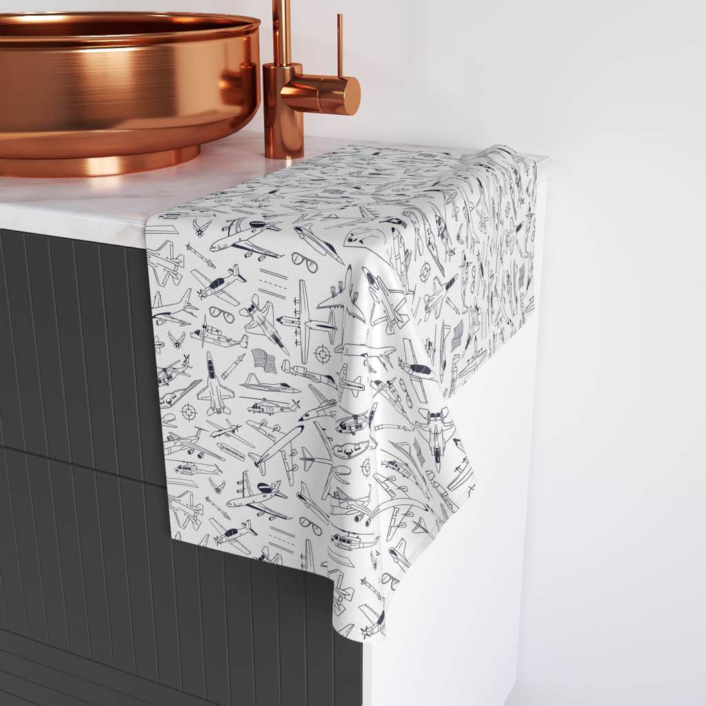 a bathroom sink with a copper-colored basin and a white towel with a pattern of airplanes on it.